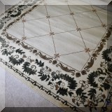 DR04. Beige rug with green vine border. 7'6” x 9'6” 